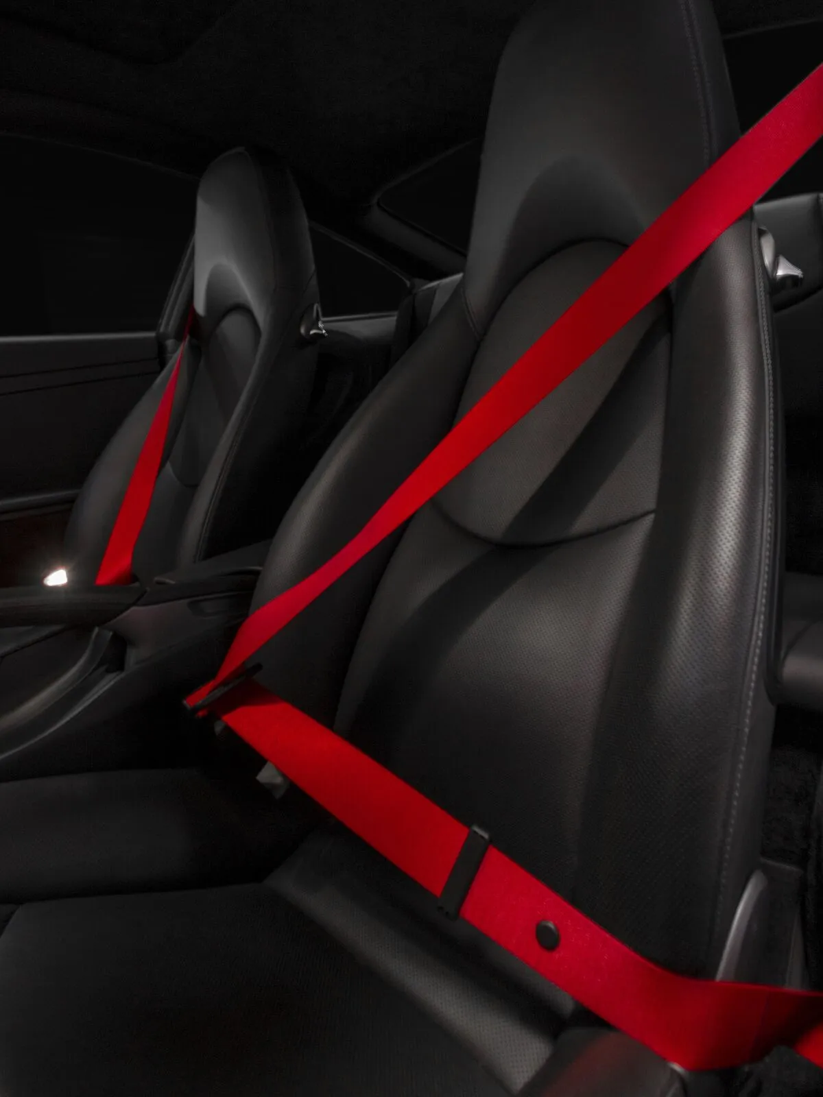Porsche interior detail with red seatbelts
